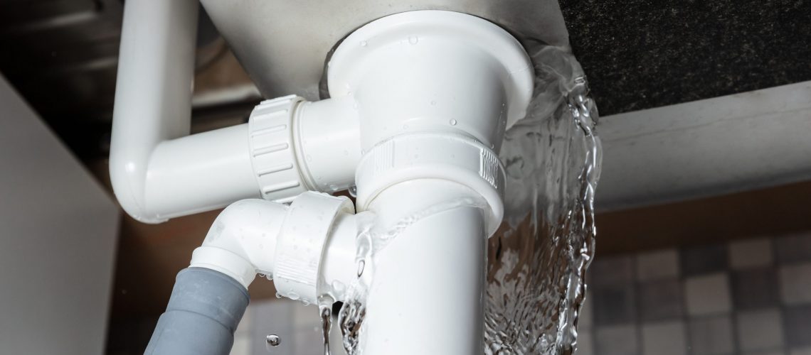Water leaking from the pipe beneath a household sink