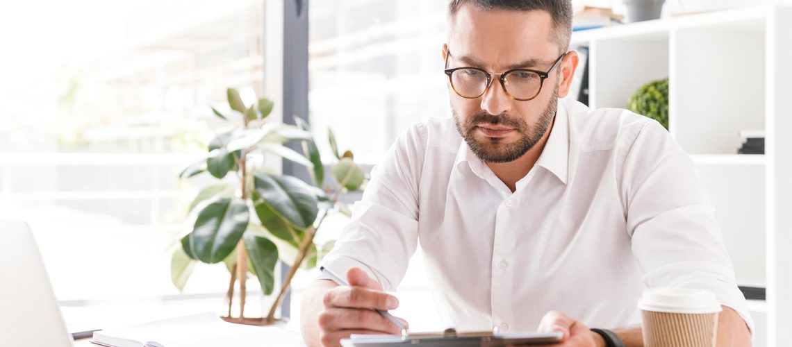 Man reviewing documents on a clipboard in an office